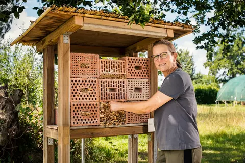 Mitarbeiterin steht vor dem Insektenhotel in Terra Medica